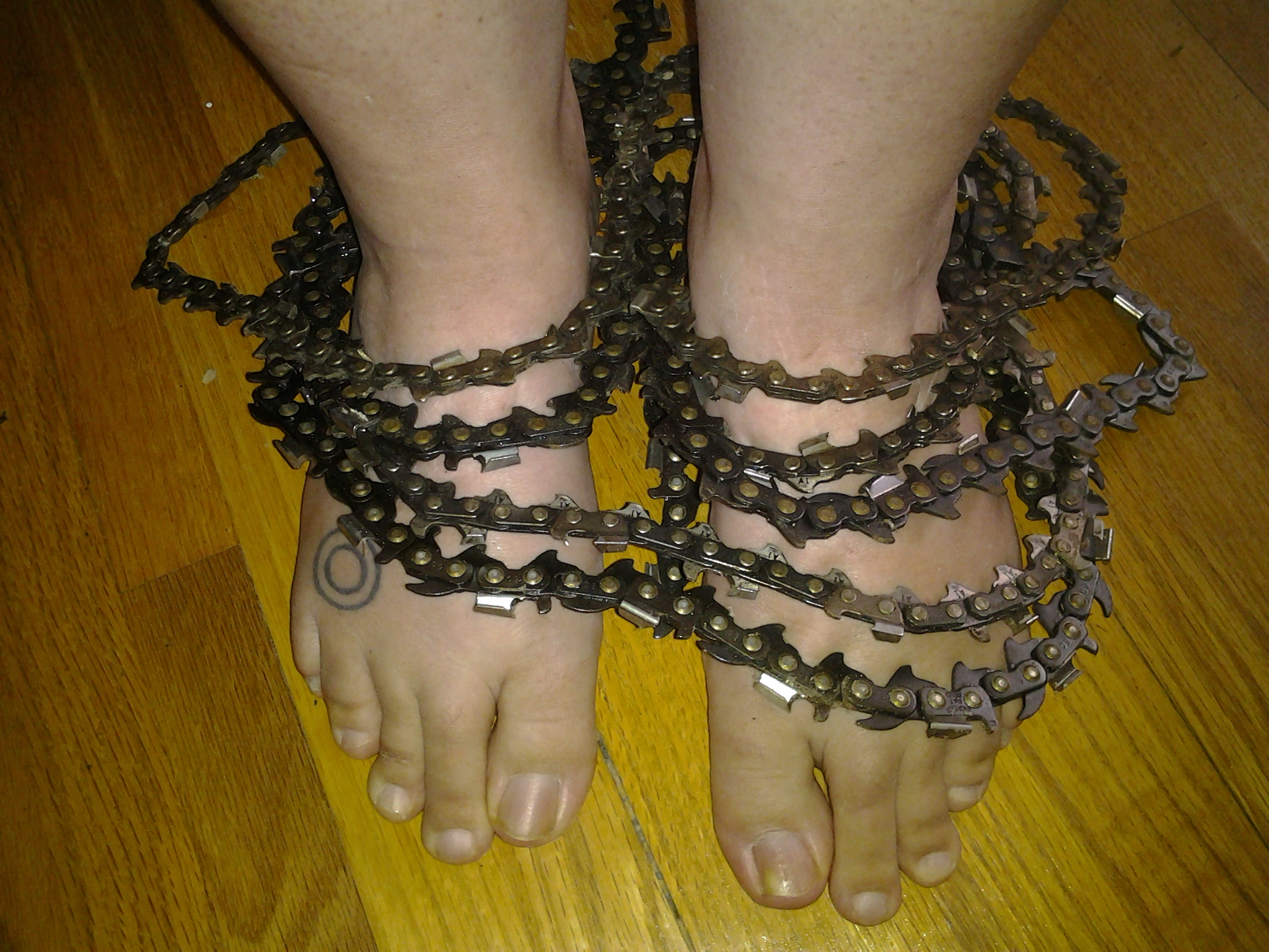 Two feet surrounded by a bike chain