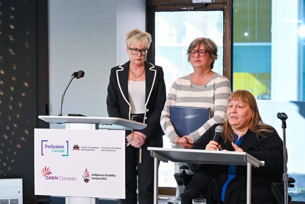 (L-R) Krista Carr, Executive Vice-President of Inclusion Canada, Bonnie Brayton, CEO of DAWN Canada, and Heather Walkus, Chair of CCD delivering their remarks at today’s press conference challenging discriminatory sections of Canada’s assisted dying law in court. (CNW Group/Inclusion Canada)