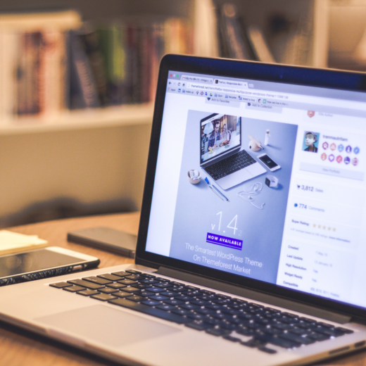 a laptop on a table in front of a bookshelf